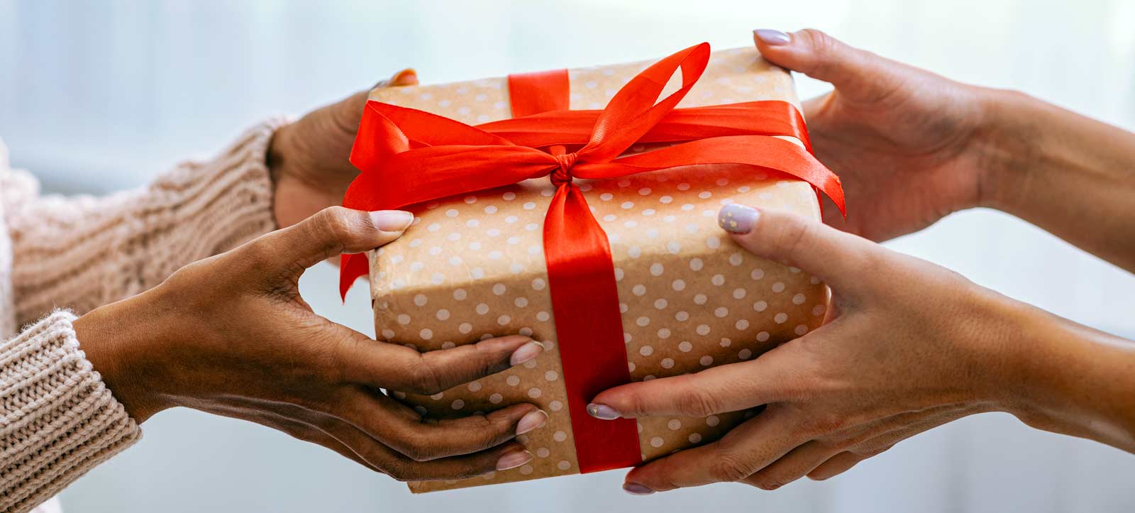 female-hands-holding-and-giving-present-to-woman-2023-11-27-05-21-48-utc